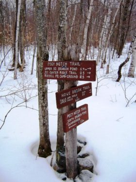 sign: "Foggy Notch Trail, . . . ." "Howe Brook Trail, . . . ." and "Pogy Notch Trail" at South Branch Pond Campsite in Baxter State Park (2006)