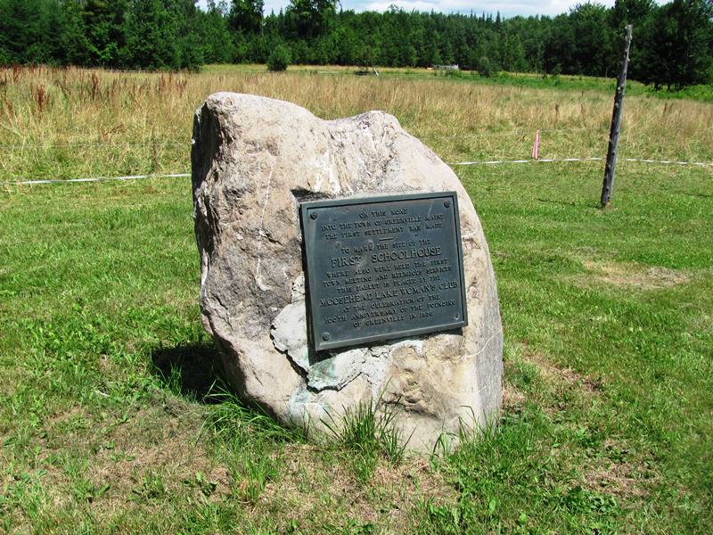 Plaque noting the early settlement of Greenville and the site of its first school