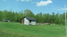Shed and vehicles on Route 11 (2012)